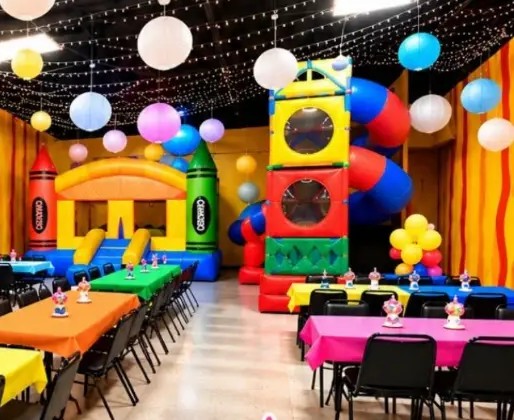 Party Room 1 decorated with balloons and lanterns, a crayon bounce house and a tall indoor play tower